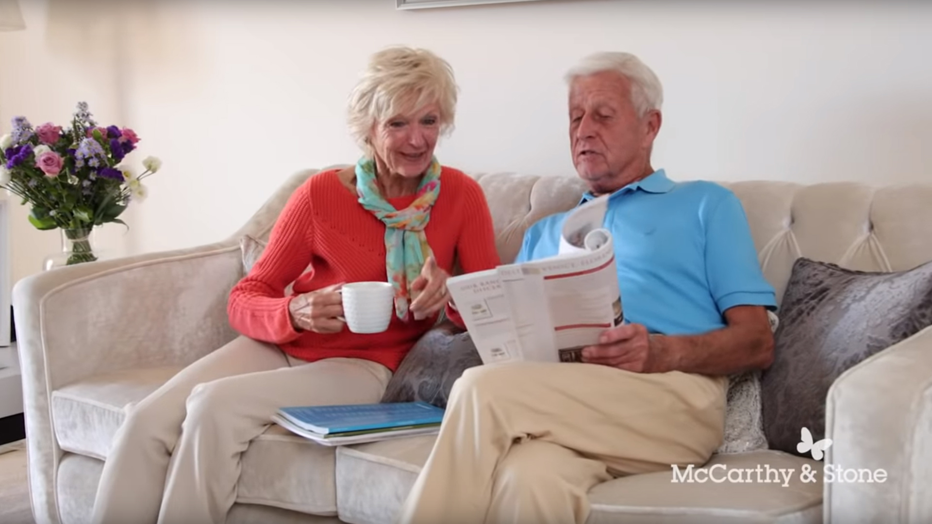 Homeowners on sofa having a drink and reading a brochure